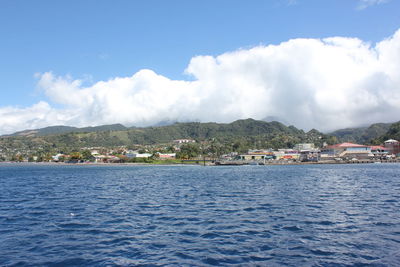 Scenic view of sea by buildings against sky