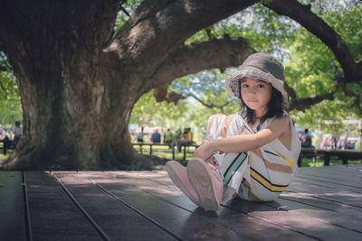 Cute little girl under the big tree in public park