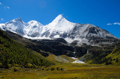 Scenic view of snowcapped mountains against blue sky