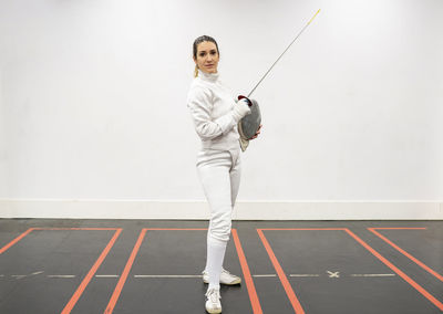 Portrait of woman in fencing outfit at gym