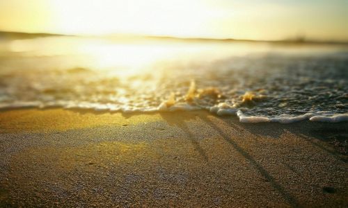 Close-up of sand at beach against sky