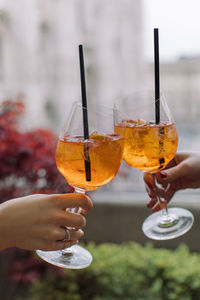 Cropped hands of friends toasting drinks in restaurant