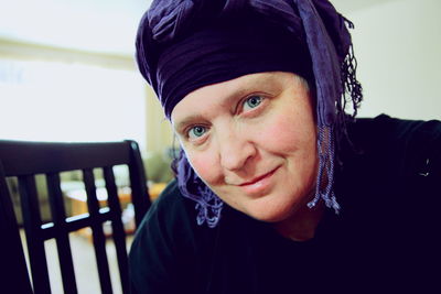 Portrait of smiling woman wearing headscarf at home