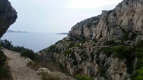 Scenic view of sea and mountains against sky