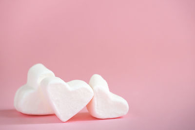 Close-up of heart shape over pink background