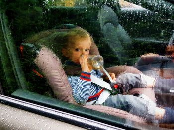 Portrait of boy looking through window