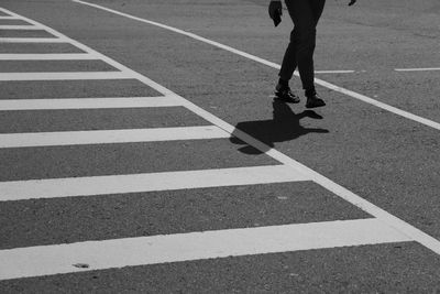 Low section of person walking on zebra crossing