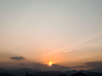 Scenic view of silhouette mountains against romantic sky at sunset