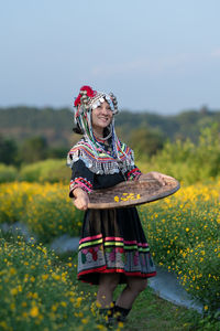 Woman with umbrella standing on field