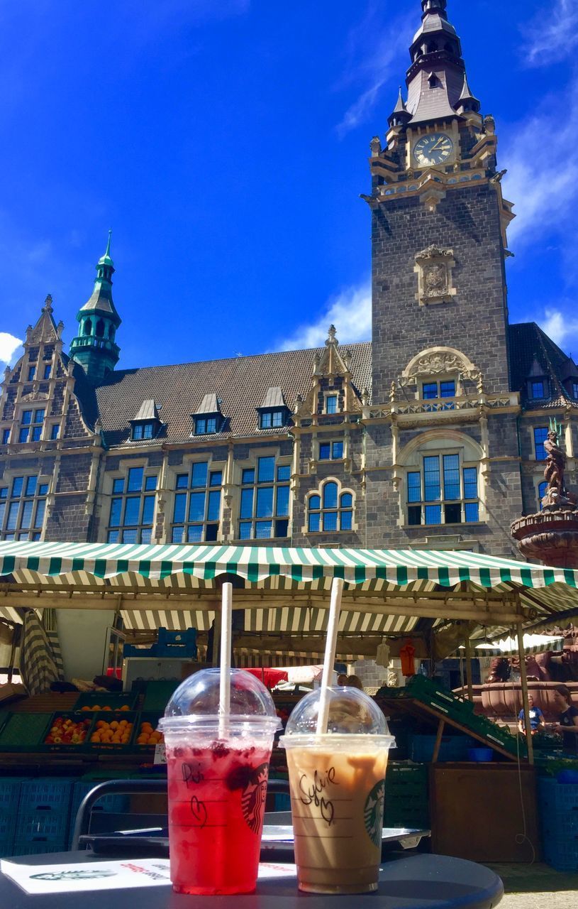 LOW ANGLE VIEW OF CLOCK TOWER AGAINST BUILDINGS