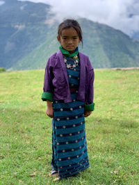 Portrait of cute girl standing on field