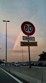 Road sign against sky during sunset