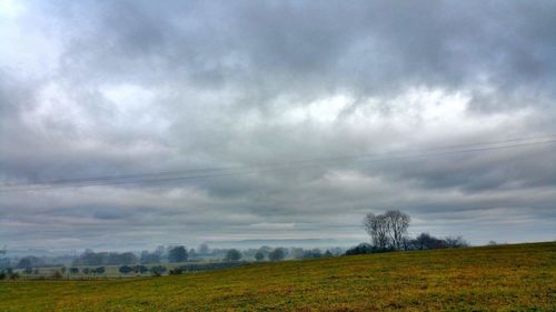 Scenic view of field against cloudy sky