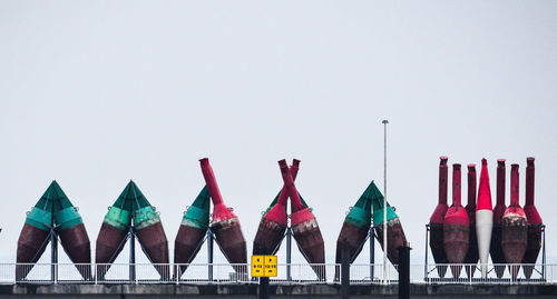 Row of multi colored buoys against clear sky