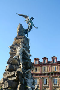 Low angle view of statue against blue sky