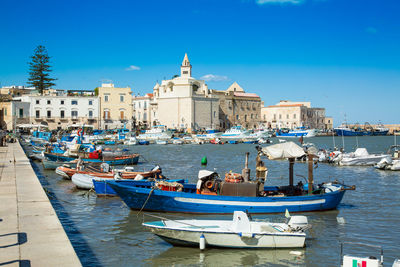 Boats moored in canal by buildings in city