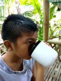 Portrait of boy drinking water from plant