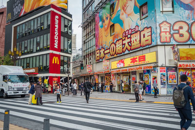 Crowded people are walking and shopping at a street in shinjuku town.