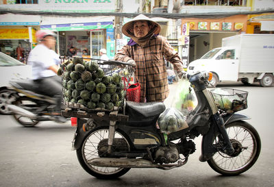 Portrait of woman riding motorcycle on street in city