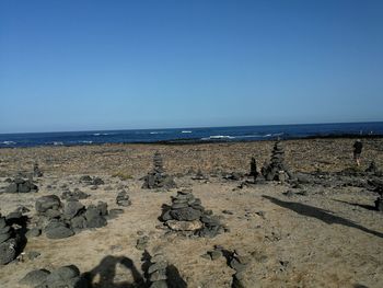 Scenic view of beach against clear blue sky