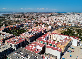 High angle view of city by sea against sky