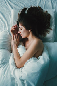 High angle view of shirtless woman sleeping on bed