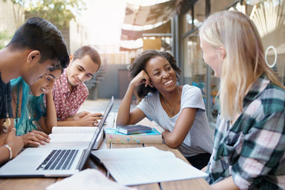 Friends using laptop at table