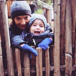 Portrait of father and son on wood outdoors