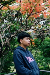 Portrait of young man looking away in forest