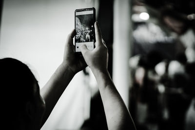 Rear view of woman photographing with mobile phone