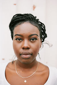 Close-up of young woman looking away against wall