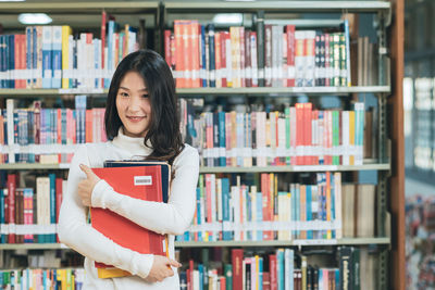 Portrait of smiling young woman reading book