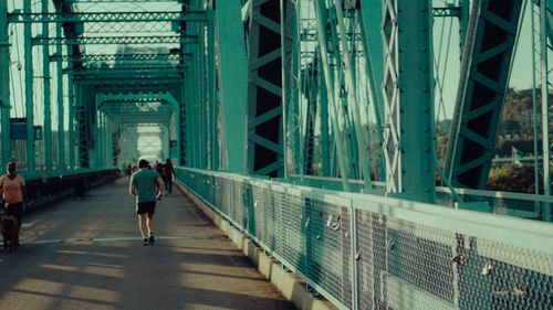 Full length of woman on footbridge in city