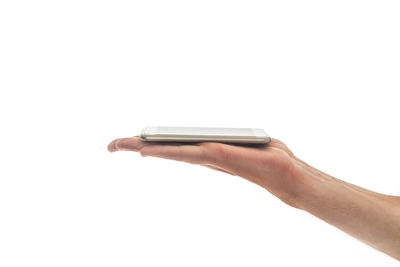 Close-up of hand holding smart phone against white background
