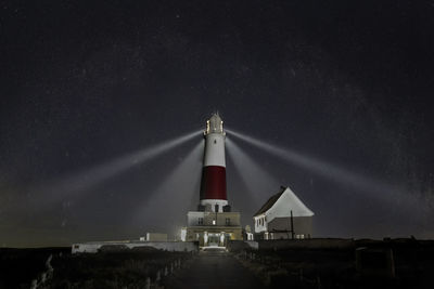 Lighthouse against sky at night