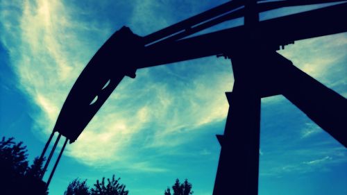 Low angle view of silhouette bridge against sky