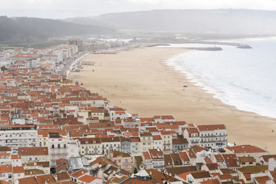 High angle view of townscape by sea against sky