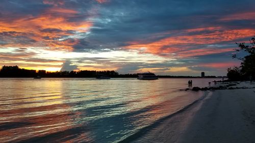 Scenic view of sea against dramatic sky during sunset