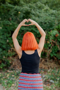 Rear view of woman standing against plants