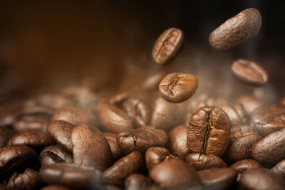 Close-up of coffee beans falling on roast coffee