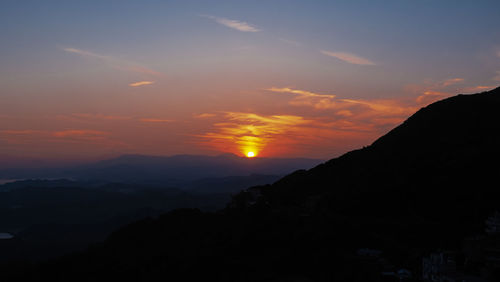 Scenic view of silhouette mountains against sky during sunset