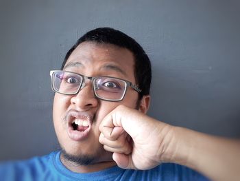 Close-up portrait of man holding eyeglasses