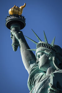 Low angle view of statue against blue sky