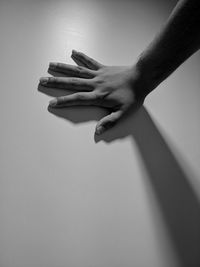 Cropped hand touching wall