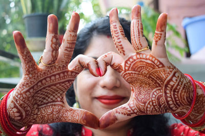 Beautiful woman dressed up as indian tradition with henna mehndi design on her both hands