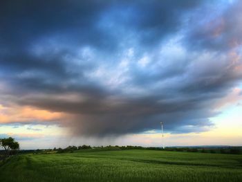 Scenic view of field against cloudy sky