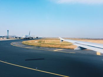 Airplane on airport runway against clear sky