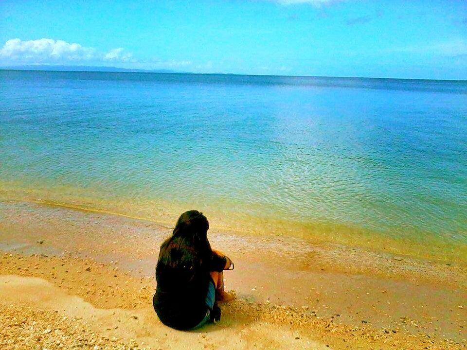 sea, water, beach, horizon over water, lifestyles, shore, leisure activity, rear view, tranquility, tranquil scene, sand, scenics, beauty in nature, vacations, sky, relaxation, sitting, nature