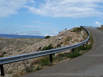 Road leading towards city against sky