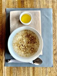 High view of a breakfast consisting of oatmeal in milk with walnuts and honey, served on the table